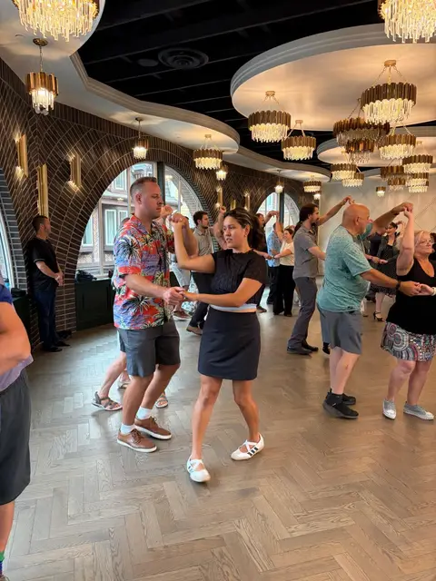 A couple practising the hand connection during the beginner salsa lesson at The Grand Hall, District 1881