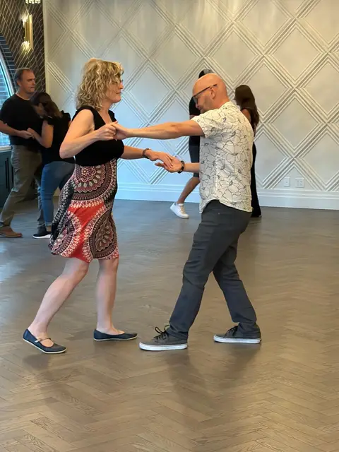 A lead and follow practising the basic step with extended arms at The Grand Hall, District 1881, Chilliwack