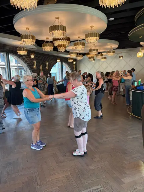 Beginner salsa pairs practising the basic step across the packed floor at Tuesday Salsa Nights, The Grand Hall, Chilliwack