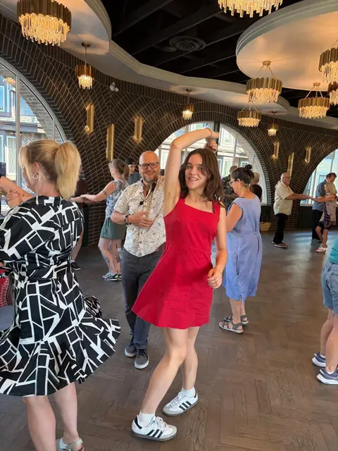 A dancer in a red dress mid-spin during the lesson at Tuesday Salsa Nights, The Grand Hall, District 1881