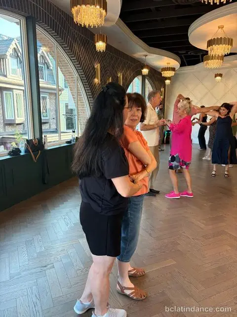 Two friends practising the basic step by the arches at Tuesday Salsa Nights, The Grand Hall, District 1881