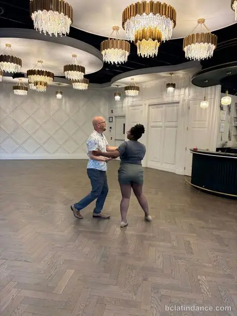 A couple dancing close hold against the white panelled wall at The Grand Hall, Chilliwack