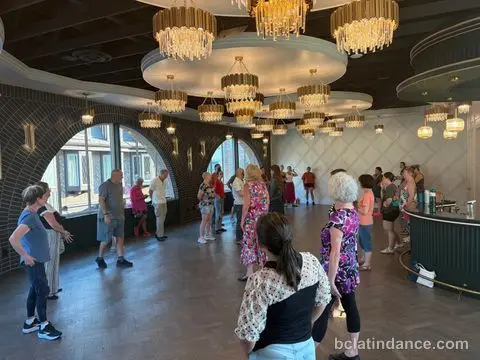 Dancers spread across the floor beneath the chandeliers at Tuesday Salsa Nights, The Grand Hall, Chilliwack