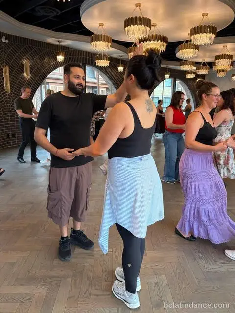 A lead sending his partner into a turn at Tuesday Salsa Nights, The Grand Hall, Chilliwack
