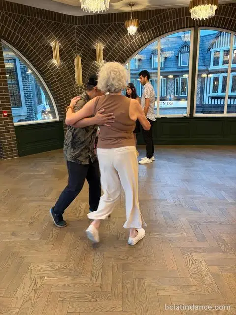 A couple dancing close hold beneath the brick arch at The Grand Hall, District 1881, Chilliwack