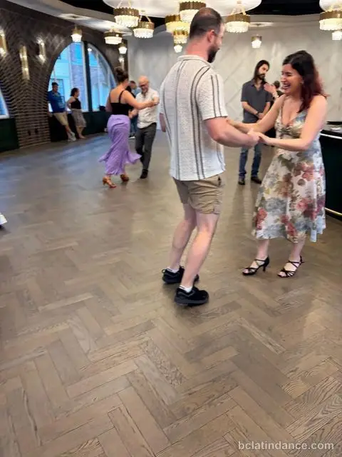 A couple laughing through a turn at Tuesday Salsa Nights, The Grand Hall, Chilliwack