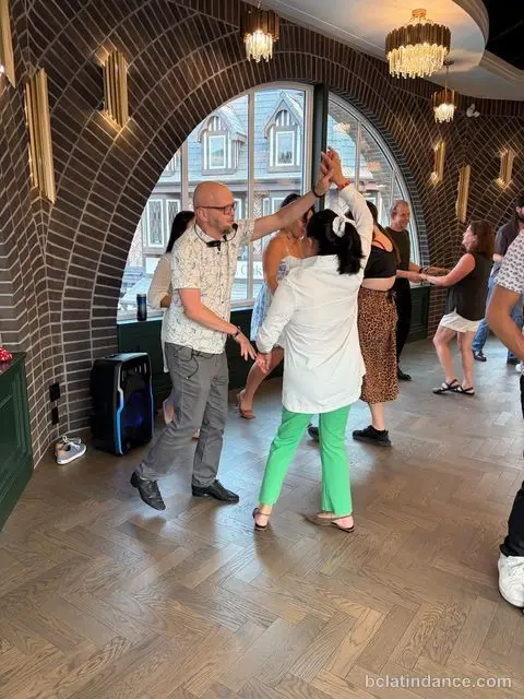 Salsa Paul leading an overhead turn under the brick arch at Tuesday Salsa Nights, The Grand Hall, Chilliwack