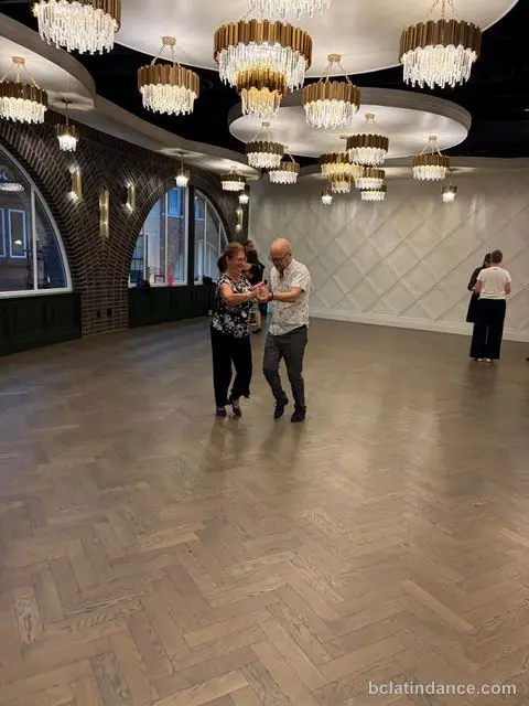 Salsa Paul dancing with a partner on the open floor during the social at The Grand Hall, District 1881