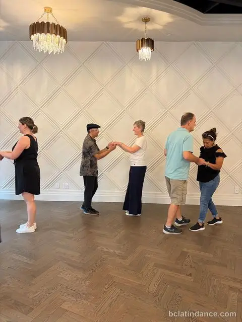 Couples practising along the white panelled wall at Tuesday Salsa Nights, The Grand Hall, Chilliwack