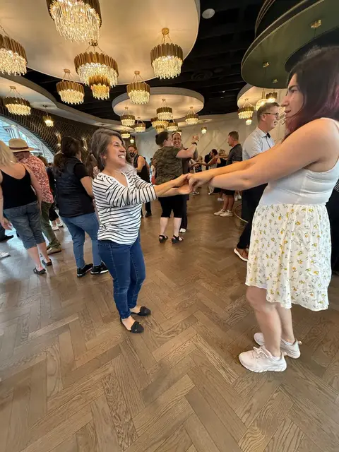 Two friends practising a turn at the beginner salsa lesson in Chilliwack
