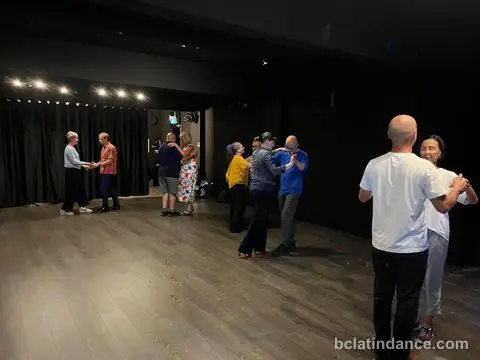Four couples working partner hold across the floor at Friday Salsa Night, Spencer Studios, Chilliwack
